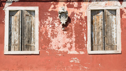 Fototapeta na wymiar Old house wall, weathered wooden shutters