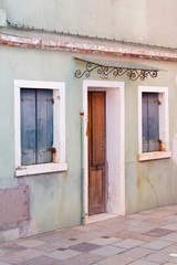 Old house wall, blue window blinds, door