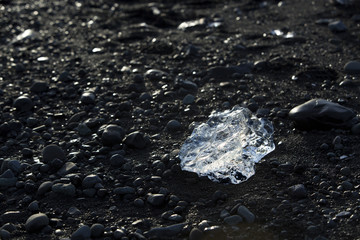 Ice block on black sand beach at glacier lagoon Jokulsarlon, Ice