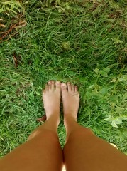 Pernas em meio ao verde da grama