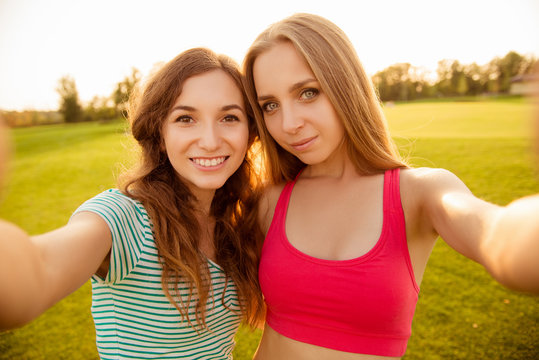 two nice-looking cheerful girls making selfie photo