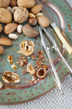 Mixture of different nuts, vintage nutcracker and knife. Selective focus
