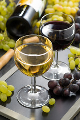 white and red wine in glasses, grapes in the background