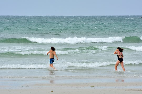 Deux enfants arrivent dans l'eau pour se baigner sur une plage en Bretagne