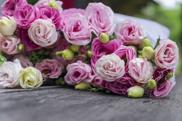 Beautiful bouquet of pink roses on wooden background