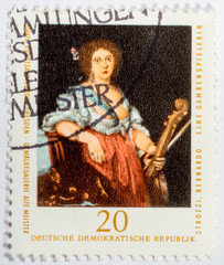 GDR - CIRCA 1976: A stamp printed in GDR shows A viol player by Bernardo Strozzi, circa 1976