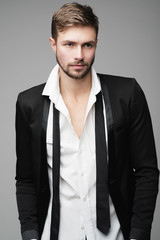 Portrait of handsome stylish man in a suit in the studio