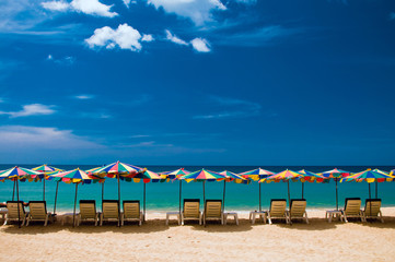 Пляжные зонтики, лежаки, голубое небо и песок на Пляже Сурин, Пхукет