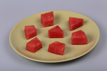 Slices of red watermelon on the green plate.