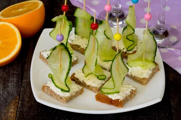 Zelfklevend Fotobehang Appetizer canape sandwich with a cucumber on a wooden table © elena_hramowa