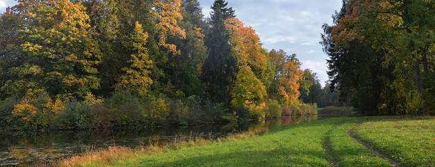 Осенний пейзаж с прудом в пригородном парке.