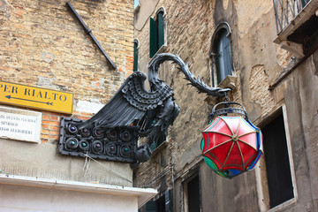 Sign with iron dragon holding colorful umbrellas