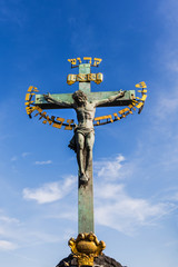 Fototapeta na wymiar Ancient sculpture of Jesus Christ crucified on the Charles Bridge in Prague, Czech Republic.