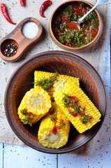 boiled corn with hot tomato sauce, herbs, salt and spices