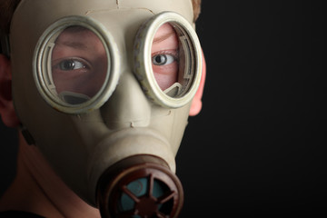 Fototapeta premium Man with gas mask on black background