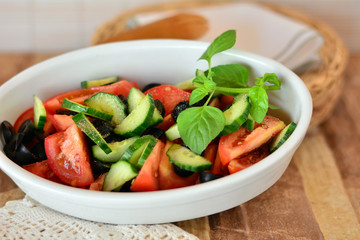 Healthy vegetable salad with cucumber,tomatoes on a white porcelain bowl