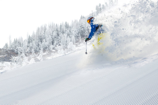 Skier skiing downhill in high mountains