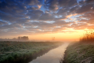 Sunrise over a misty small river