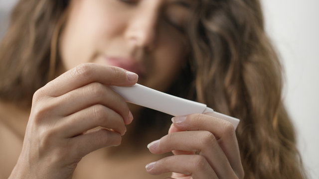 Blurred female awaiting result of pregnancy kit
