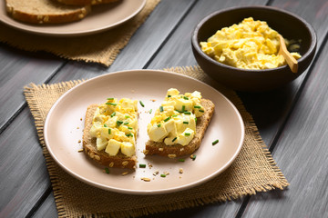 Egg Salad Sandwich, egg salad prepared with mayonnaise and mustard on wholegrain bread with chives, photographed with natural light (Selective Focus, Focus on the front of the sandwiches)