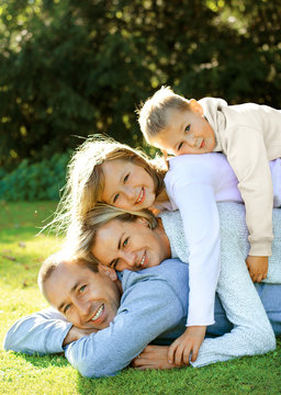 happy family lying on the grass and smiling