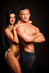 Fototapeta na wymiar Fitness couple poses in studio - fit man and woman
