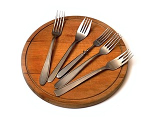 forks on a wooden round breadboard on white background