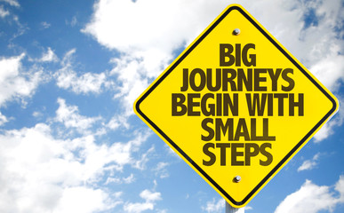 Big Journeys Begin With Small Steps sign with sky background