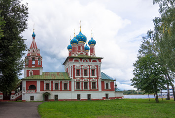 Fototapeta na wymiar built on the site where 9 year old Dimitry suddenly died is the Church of St. Dimitry painted dramatic pink and white with its green roof and bright blue domes with gold stars in Uglich, Russia 