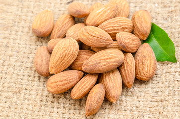 Raw almond with green leaf.