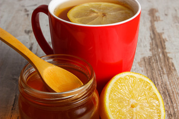 Fresh lemon, honey and cup of tea on wooden table, healthy nutrition