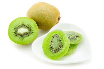 Dried kiwi in white dish and fresh kiwi.
