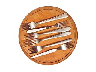 six forks on a wooden round breadboard