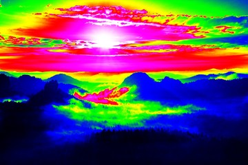 Misty view. Amazing thermography photo of hilly landscape. Autumn sunset above long deep valley with heavy fog above forest.