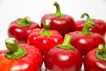 Many ripe red peppers on over white