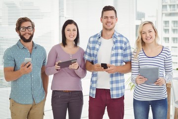 Portrait of smiling business people using electronic gadgets 