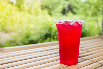 Soft drinks in plastic cups on bamboo table