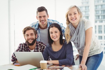 Portrait of smiling business people using laptop 