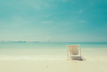 beach chair on beach with blue sky - soft focus with film filter
