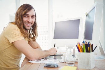 Portrait of happy hipster working at desk