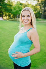 Beautiful pregnant woman relaxing in the park