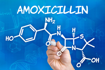 Hand mit Stift zeichnet chemische Strukturformel von Amoxicillin