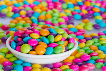 Colorful candies on the white ceramic bowl