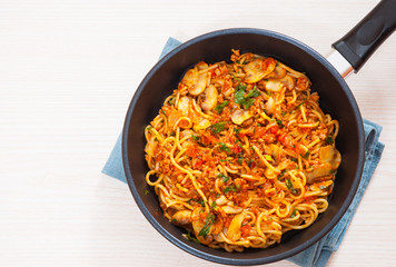 spaghetti with mushroom and minced meat in a frying pan
