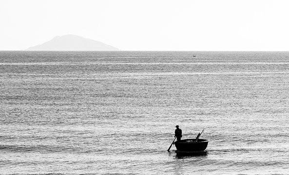 Fototapeta Fisherman in round boat on the sea in black and white vintage style