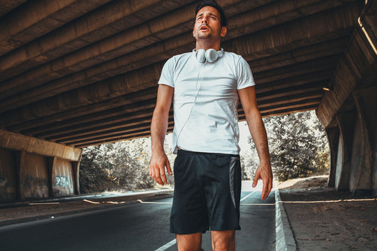 Exhausted man walking after jogging