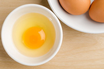 Egg yolk in the bowl on wooden background