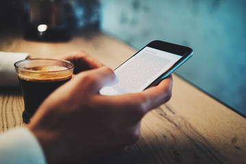 Cup of coffe and girl using her smart phone