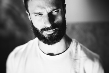 BW portrait of a bearded man wearing white tshirt on the blure