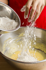 Pouring the flour into the mixture,making bakery